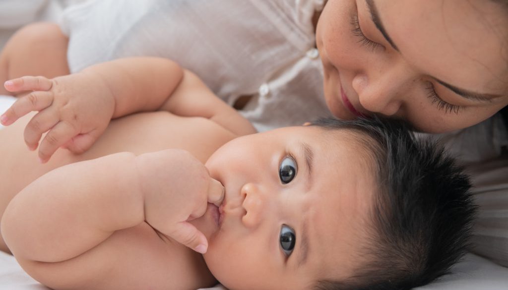 Loving mom carying of her newborn baby at home. Bright portrait